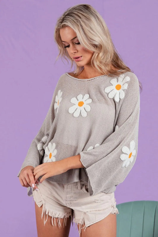 Loose fit gray knit top with white daisy embroidery on a model.