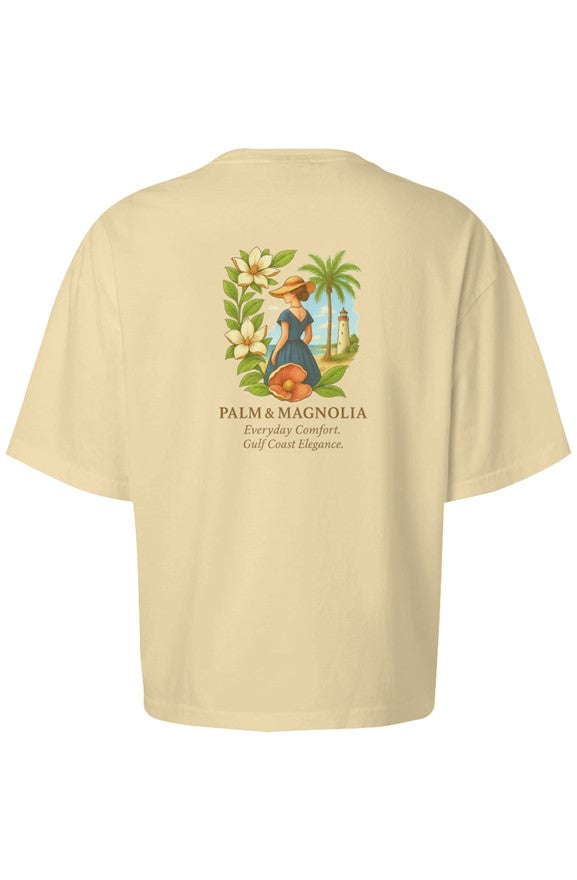 Back view of a cream Comfort Colors women's boxy T-shirt with Palm & Magnolia logo and tropical design.