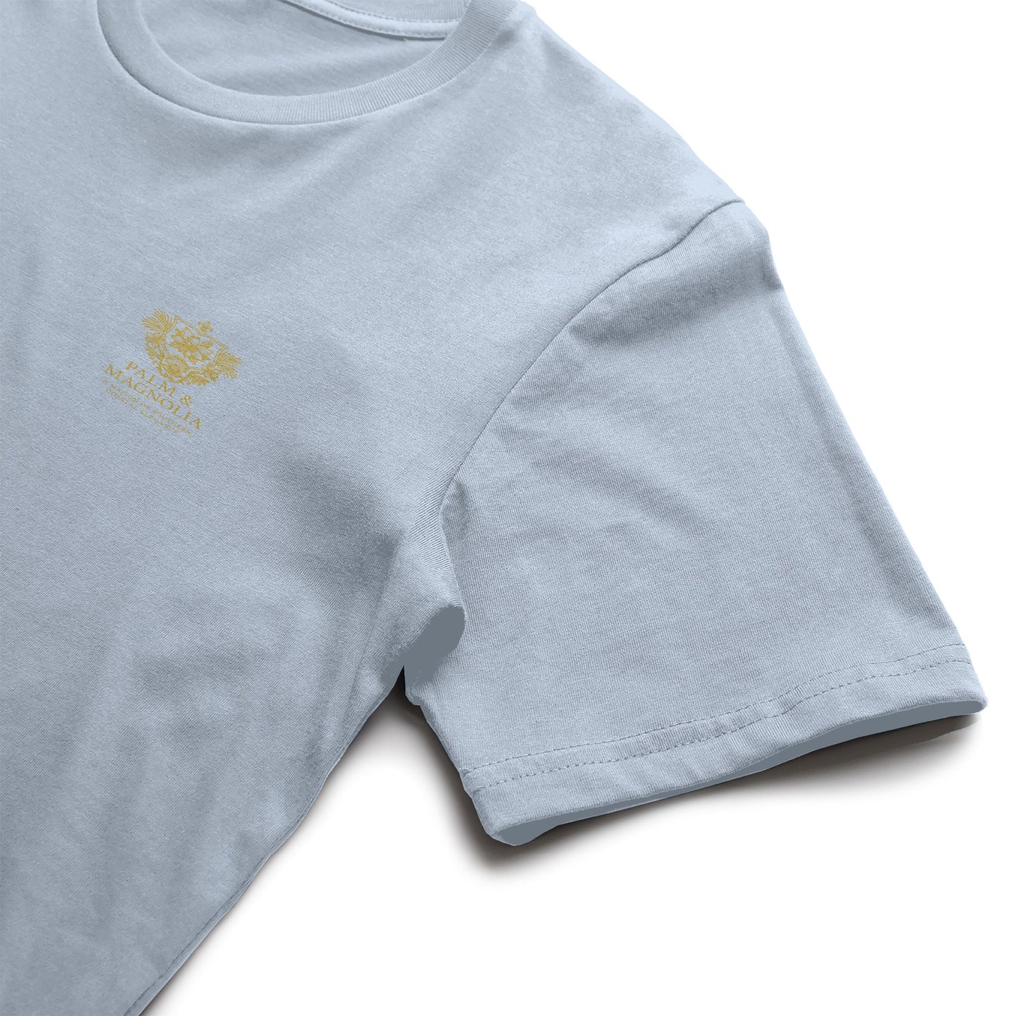 Light pink Bella Canvas T-shirt with embroidered magnolia blossom on the chest.