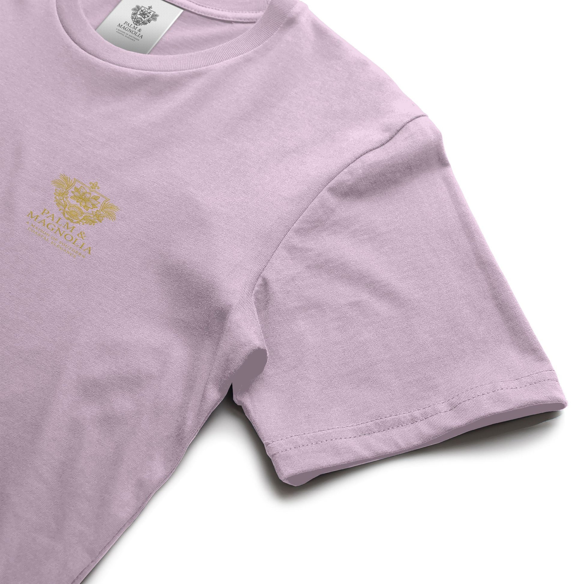 Light pink unisex ring-spun cotton tee with gold Palm & Magnolia crest on chest.