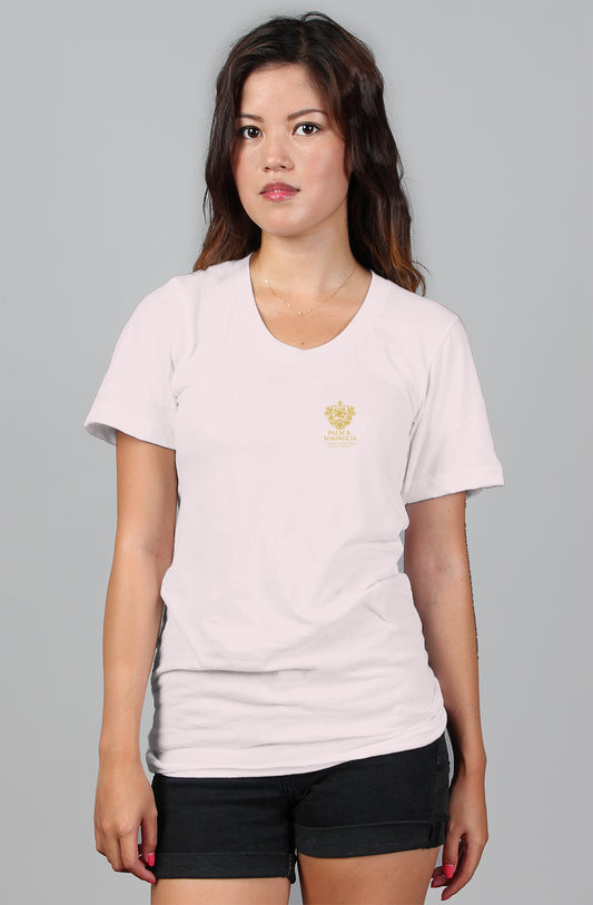 Woman modeling a white relaxed-fit women's tee with a gold crown emblem.