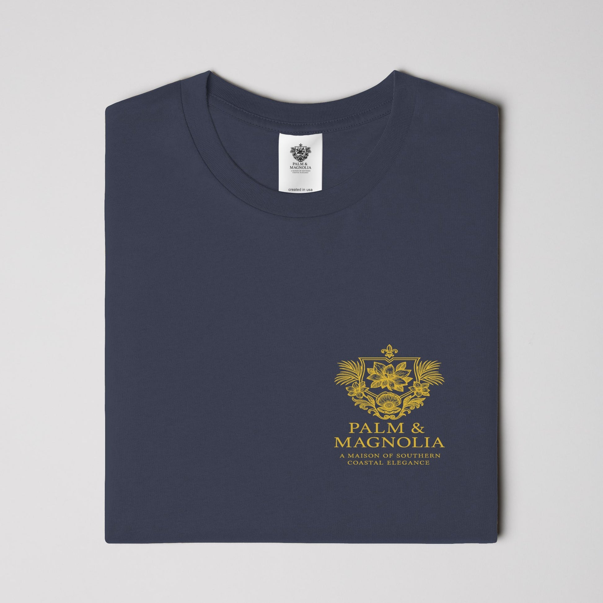 Folded navy Comfort Colors heavyweight T-shirt with gold Coastal Companions Bayou La Batre logo.
