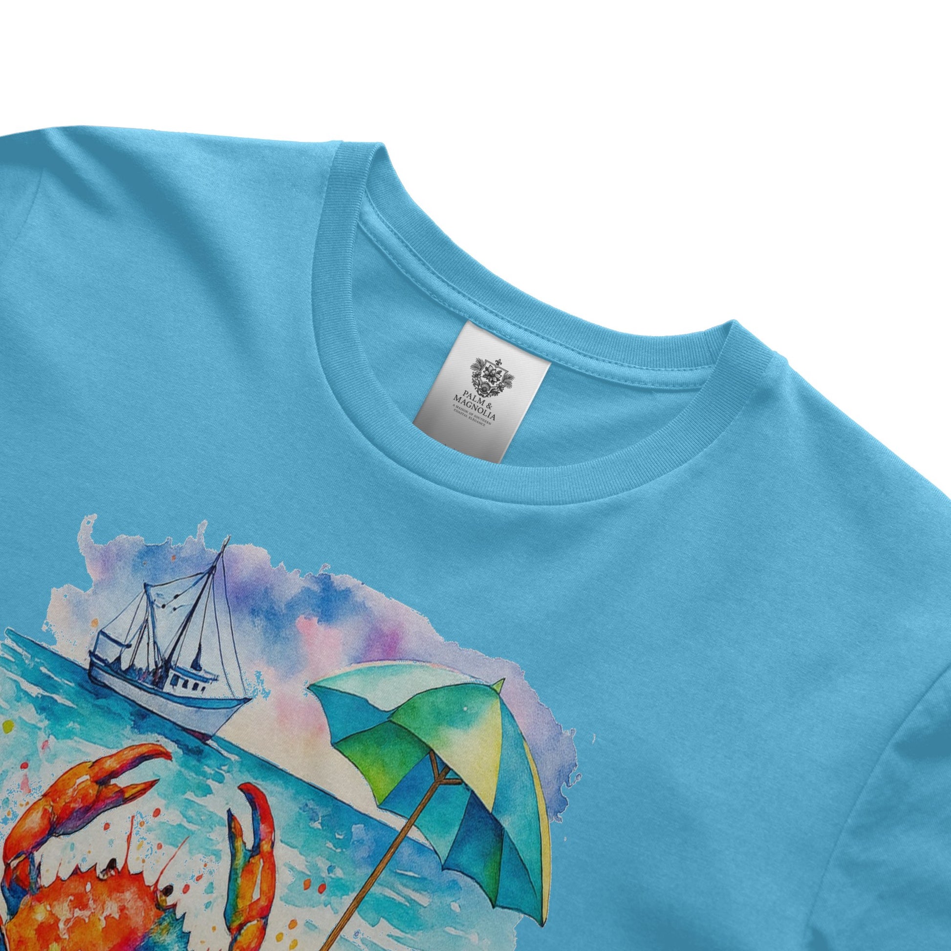 Light blue unisex cotton t-shirt with watercolor crab, sailboat, and beach umbrella print on front.