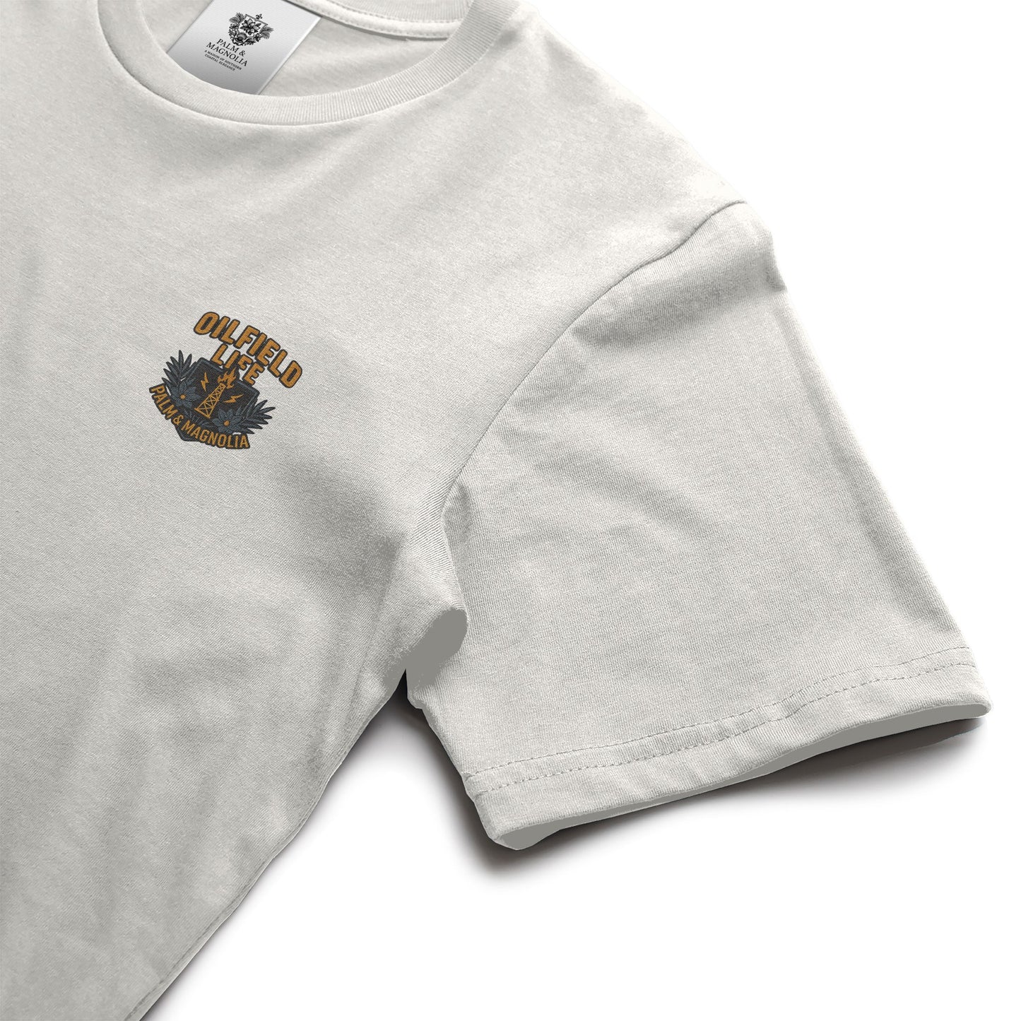 White heavyweight cotton t-shirt with "Oilfield Life" palm and magnolia emblem on chest.