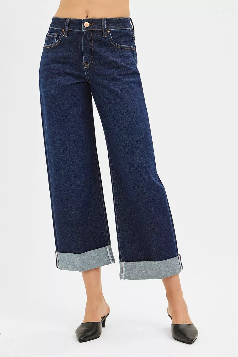 Mid-rise ankle wide-leg jeans in dark wash with rolled cuffs, modeled on a woman.