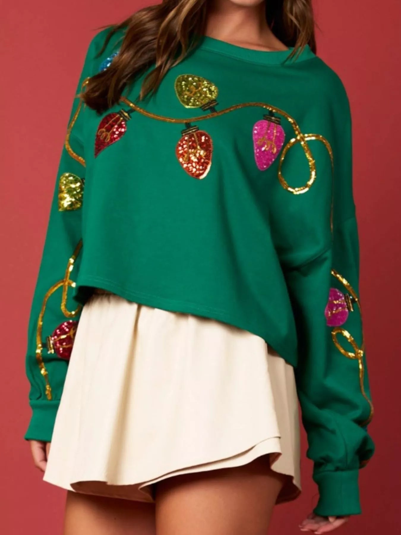 A cozy sweatshirt featuring shimmering sequin embellishments in a festive design.
