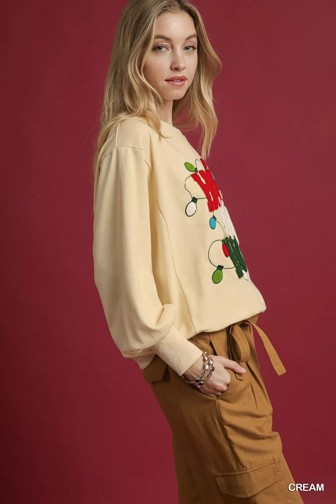 Cream French terry sweatshirt with colorful floral applique on sleeves and hem.