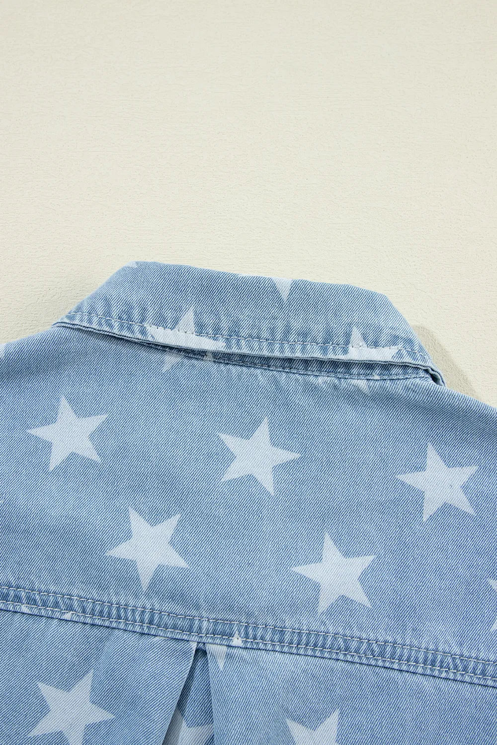 Denim top with raw hem and star collar in cotton blend fabric.