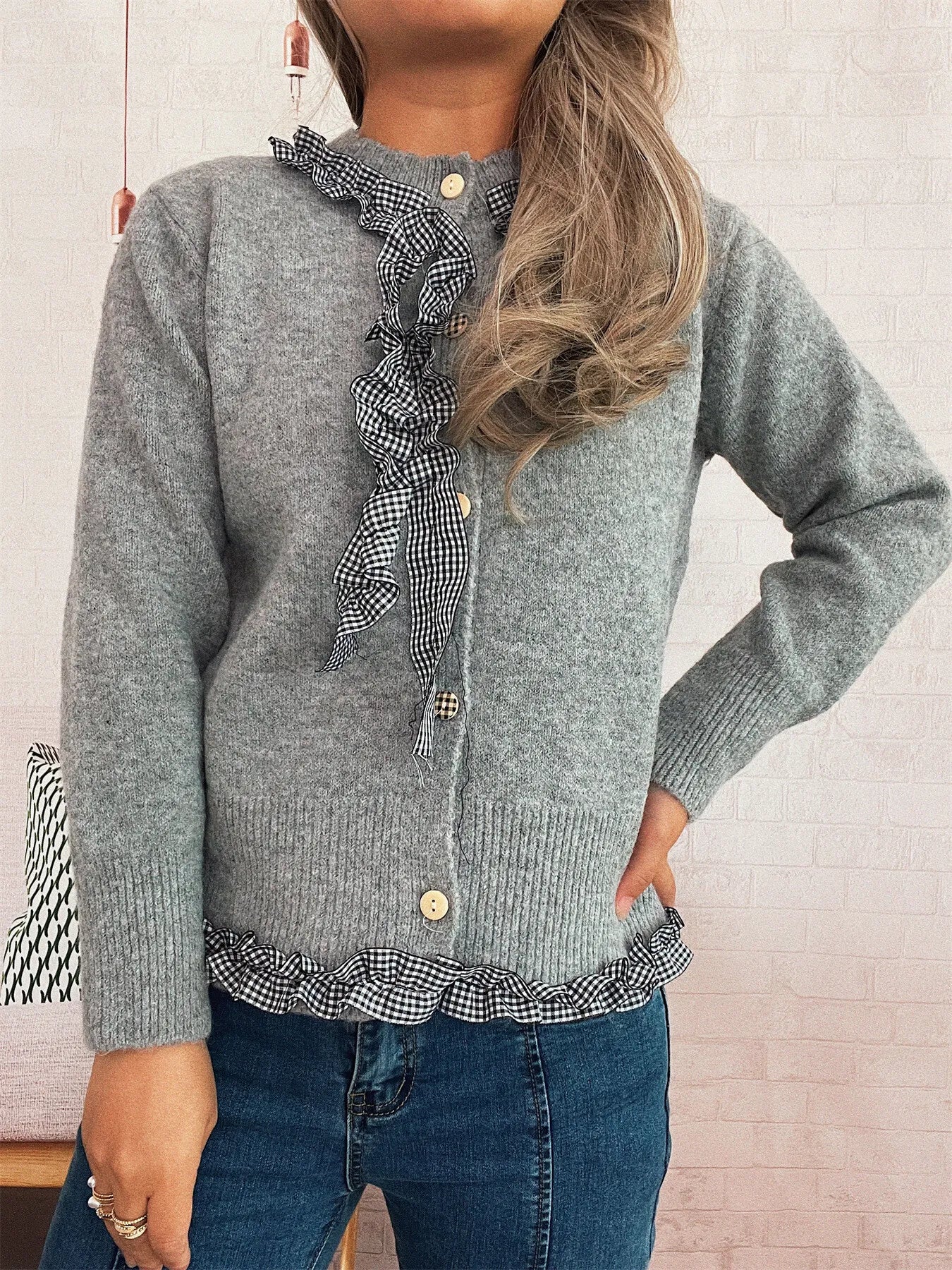 Lightweight gingham cardigan with ruffle trim and button closure, made of 100% polyester.