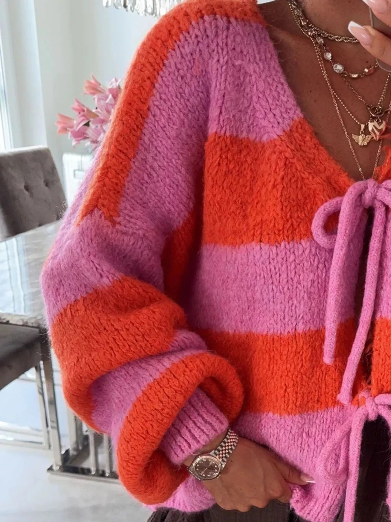 Striped knit cardigan with a tie-front, slightly stretchy fabric, and long sleeves.