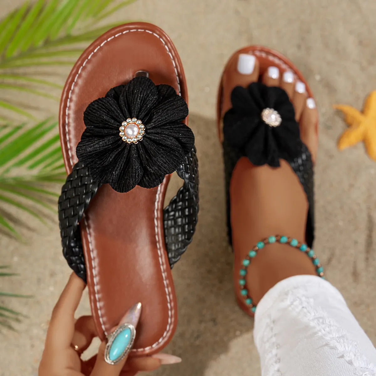 Brown leather toe post sandals with black flower accents and turquoise bead details on braided straps.