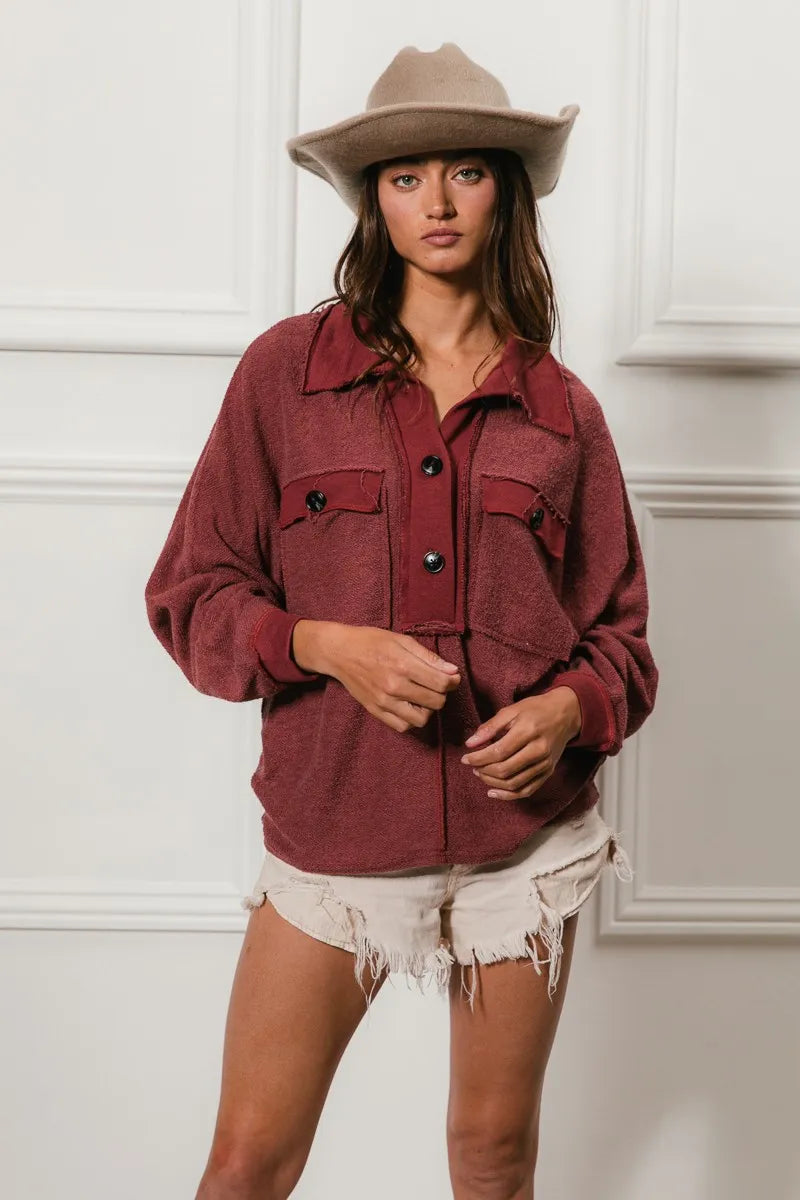 Oversized maroon French terry collared top with buttons and pockets, modeled on a woman.