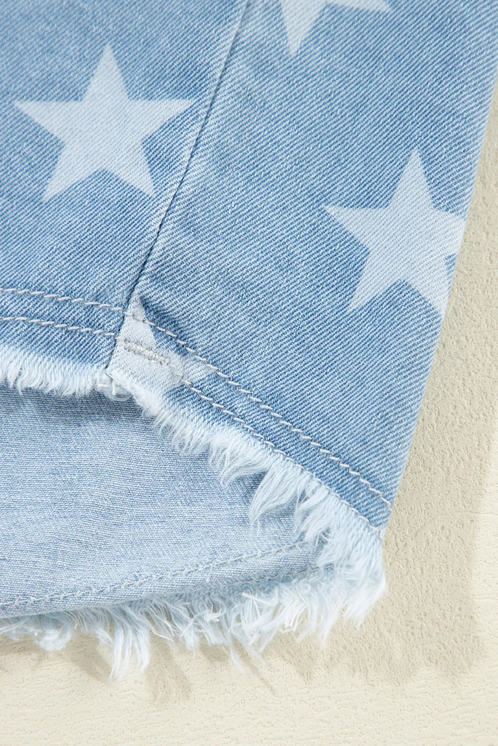 Denim top with raw hem and star collar in a cotton blend fabric.