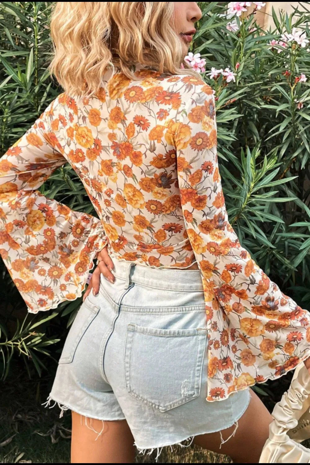 A slightly stretchy polyester top with a mock neck and fashionable flare sleeves.