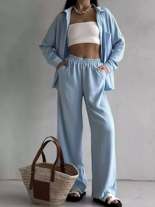 Woman modeling a light blue two-piece set with button-down shirt and wide-leg pants.