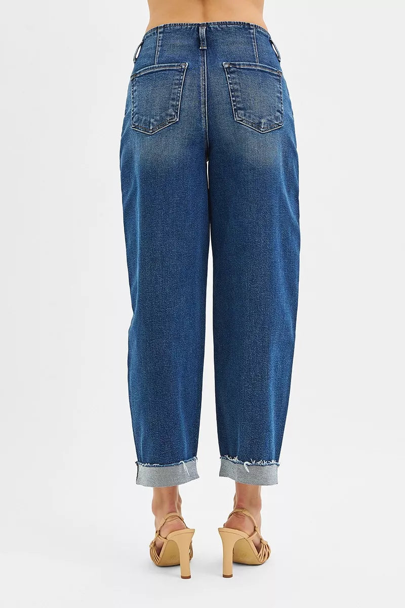 Rear view of high-rise barrel cuffed jeans in stretch denim with raw hem.