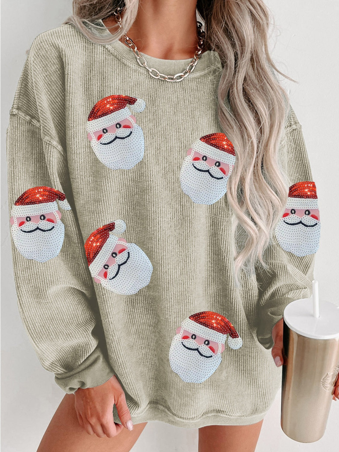 Gray ribbed sweatshirt with sequin Santa patches and a model holding a tumbler.