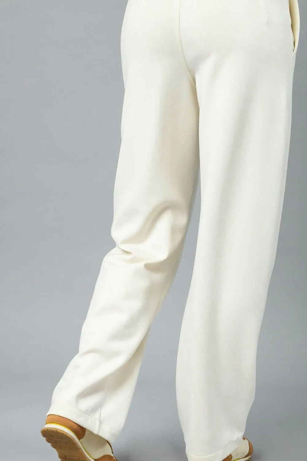 Cream high-waisted wide-leg pants in linen blend, rear view showing pockets and relaxed fit.