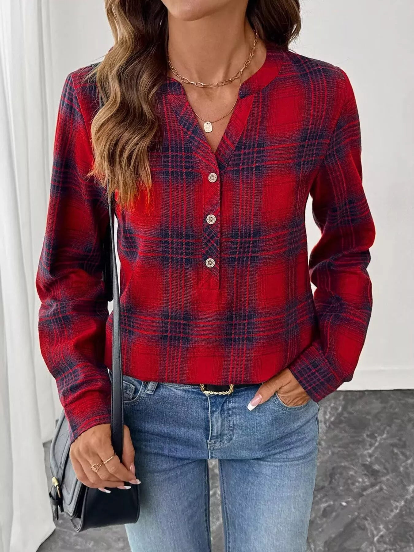 Plaid long sleeve blouse with half button closure, made from polyester blend fabric.