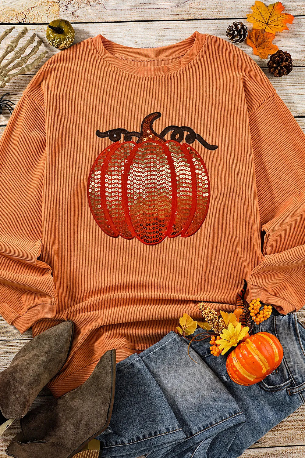 Long sleeve round neck sweatshirt with sequin pumpkin design and cozy fit.