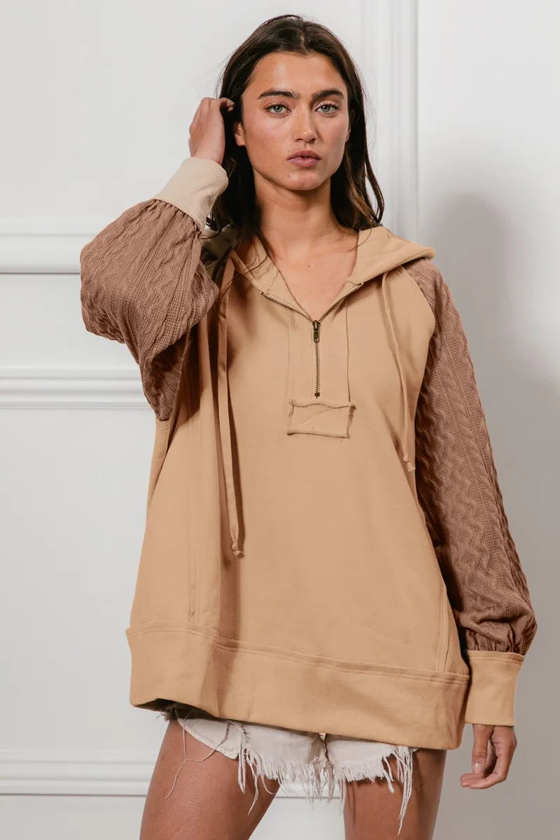 Model poses in BiBi Half Zip French Terry Hoodie with knit sleeves, in beige.