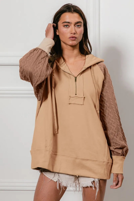 Model poses in BiBi Half Zip French Terry Hoodie with knit sleeves, in beige.