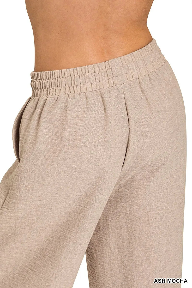 Side view of ash mocha woven crepe wide-leg pants with elastic waistband and pockets.
