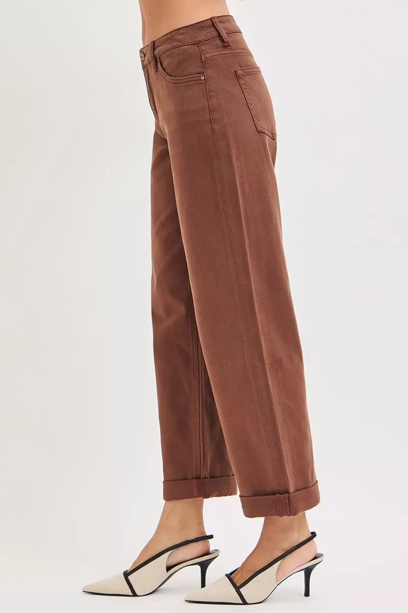 Brown wide-leg high-rise jeans in plus size, modeled from side view with cuffed hems.