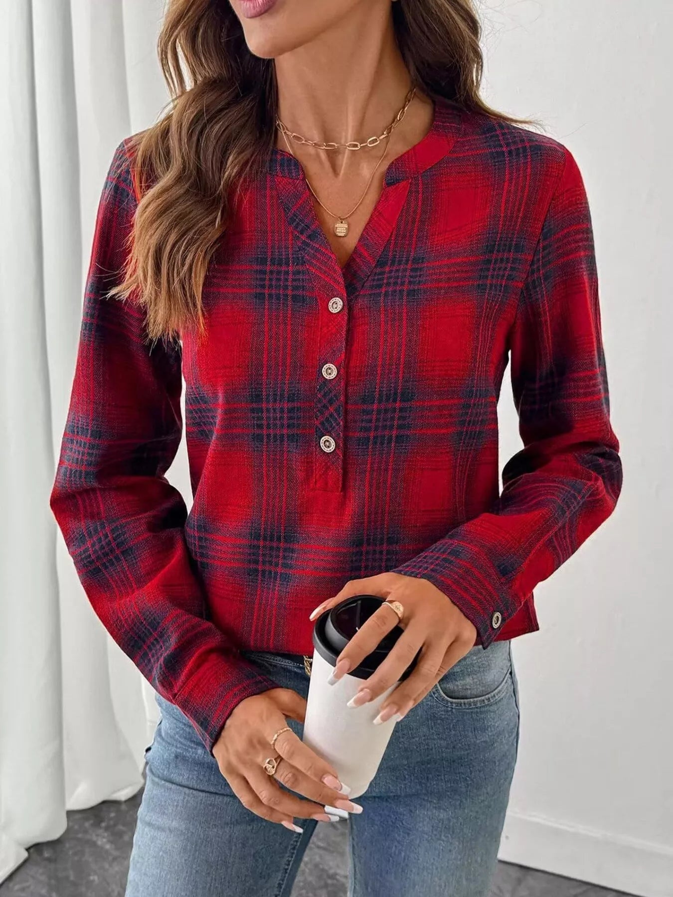 Plaid long sleeve blouse with half button front, made of polyester and spandex blend.