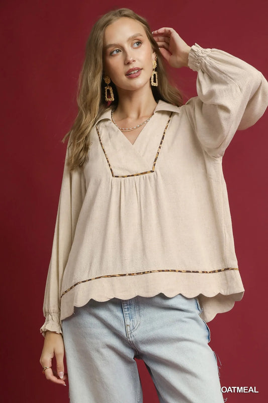 Woman modeling beige linen scallop hem blouse with contrast trim.