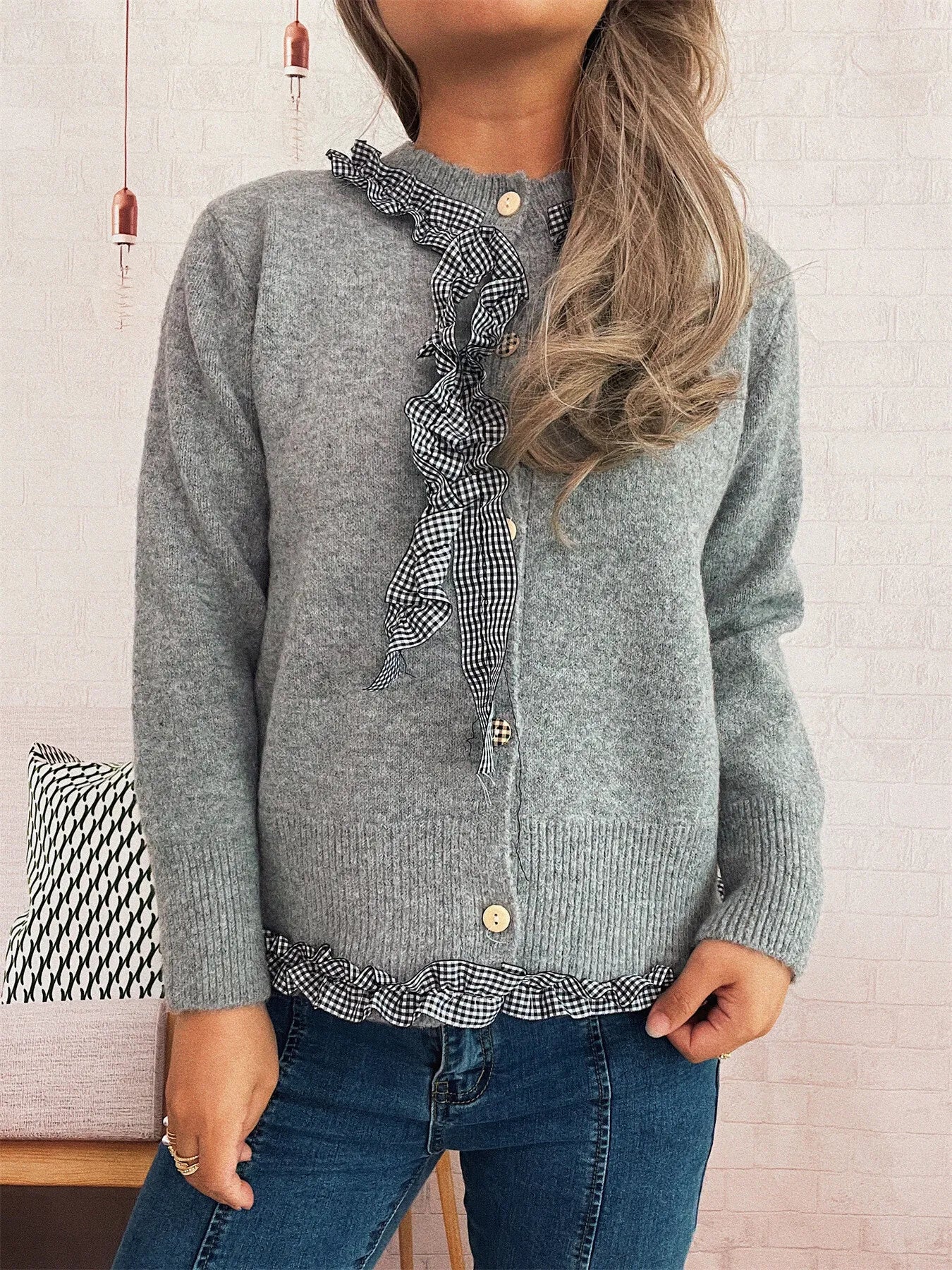 A ruffle trim gingham cardigan in stretchy 100% polyester with button closure.