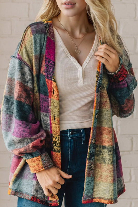 Woman wearing a multicolor plaid fleece shacket with open front and wide sleeves.