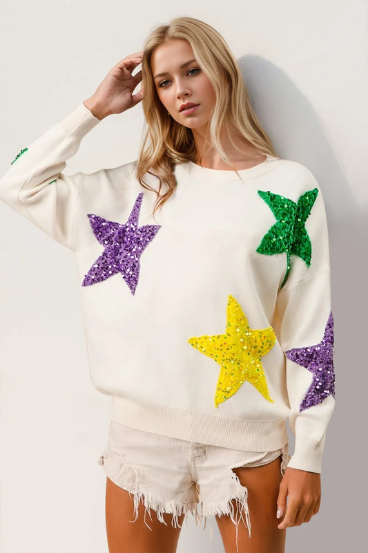 Creamy white dropped shoulder sweater with purple, green, and yellow sequin stars.