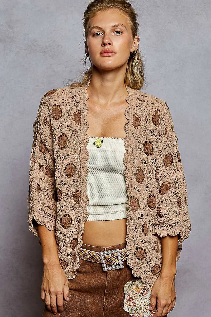 Woman modeling a beige openwork V-neck chenille cardigan with floral contrast.