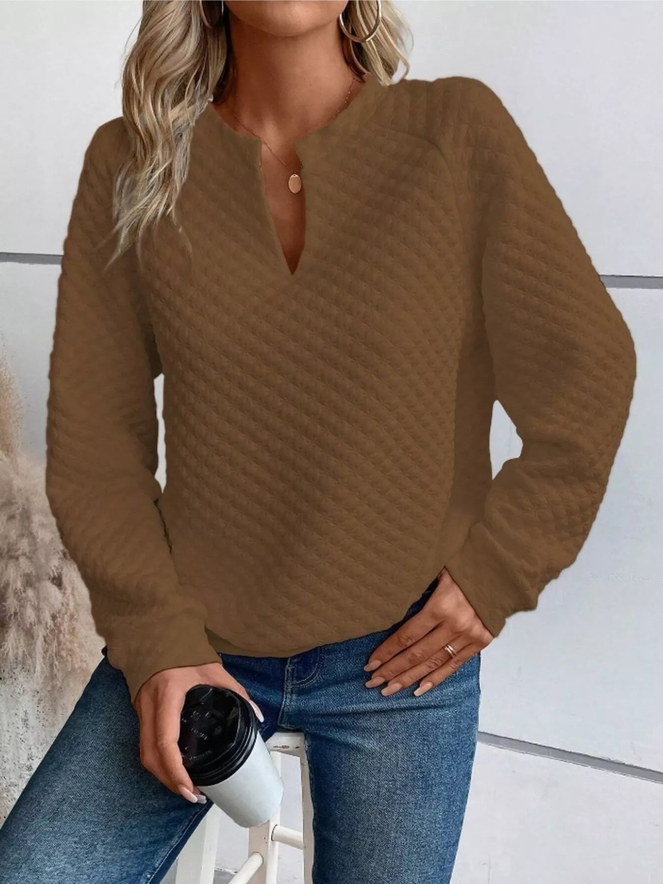 Light gray textured sweatshirt with notched raglan sleeves and a relaxed fit.