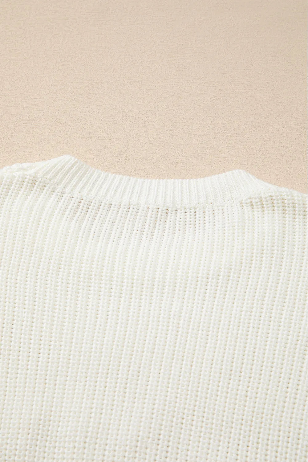 Cream acrylic cotton round neck sweater with ribbed knit texture.