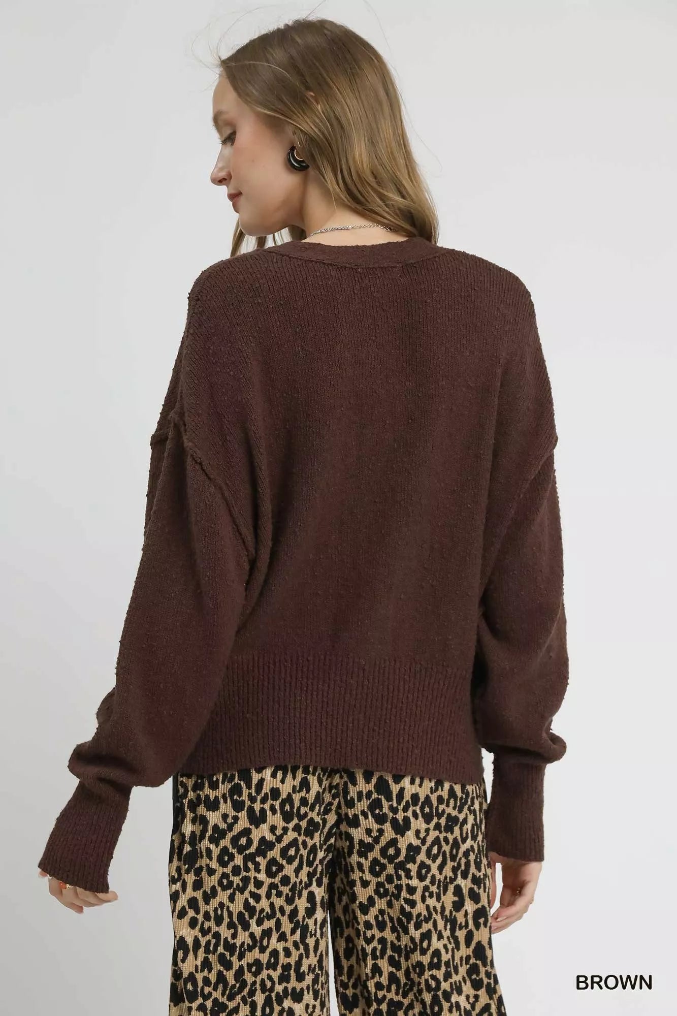 Oversized button-front V-neck knit cardigan in hemlock brown, shown from back on model with leopard pants.
