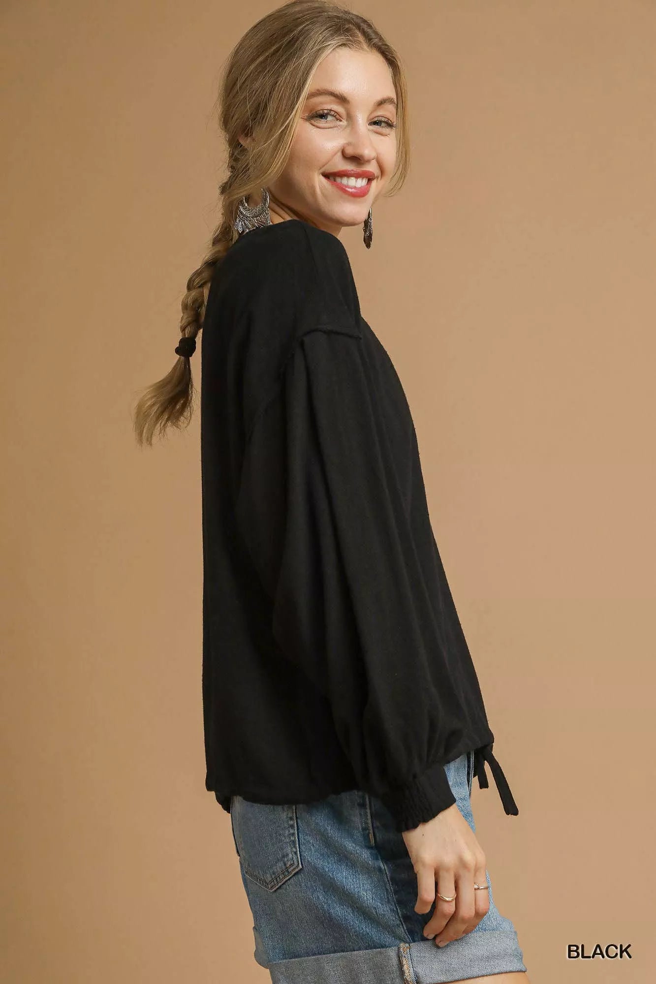Plus-size linen long-sleeve top with drawstring detail, modeled on a woman.