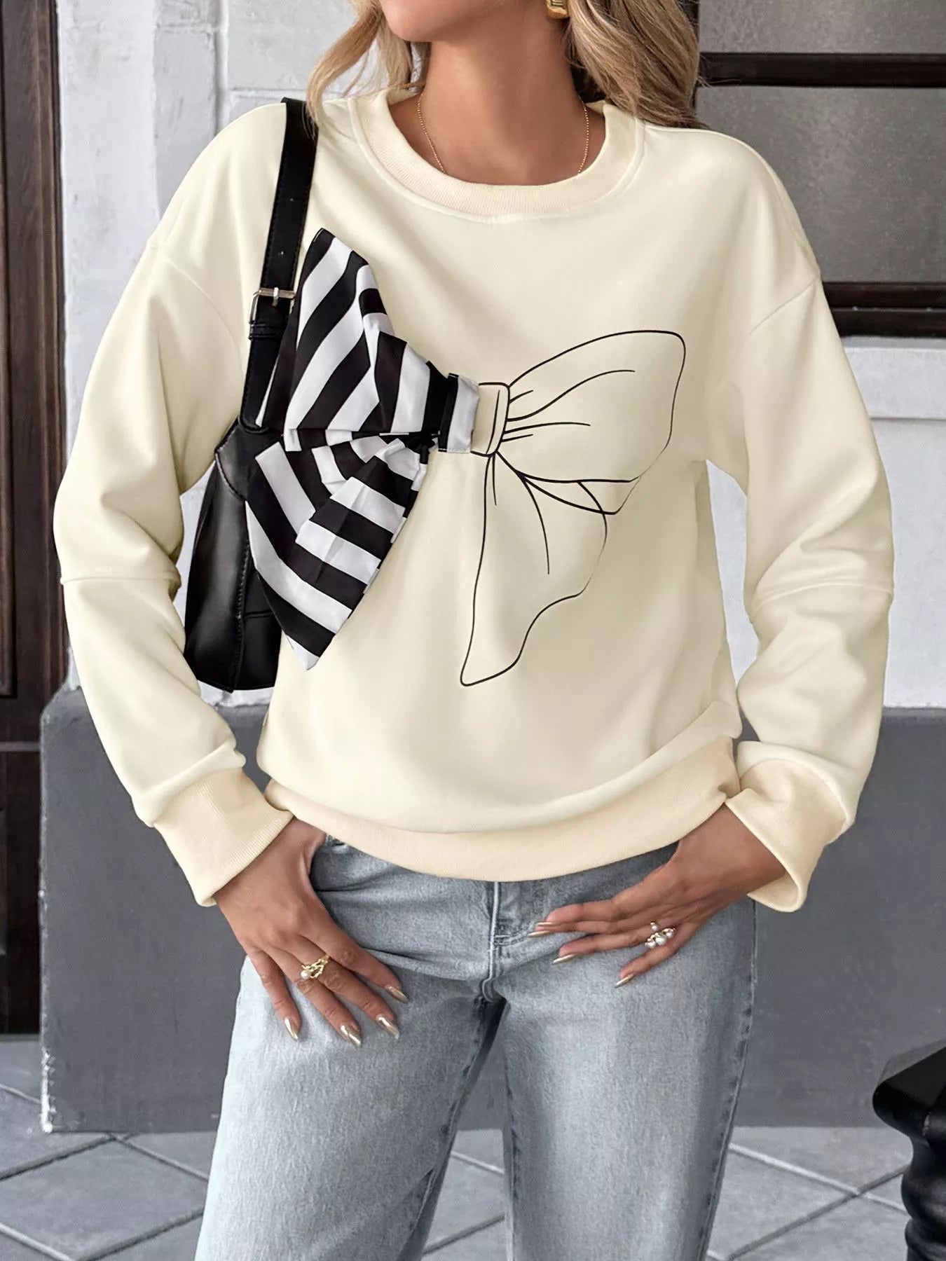 Light gray sweatshirt with a bow detail and dropped shoulders, made of polyester blend.