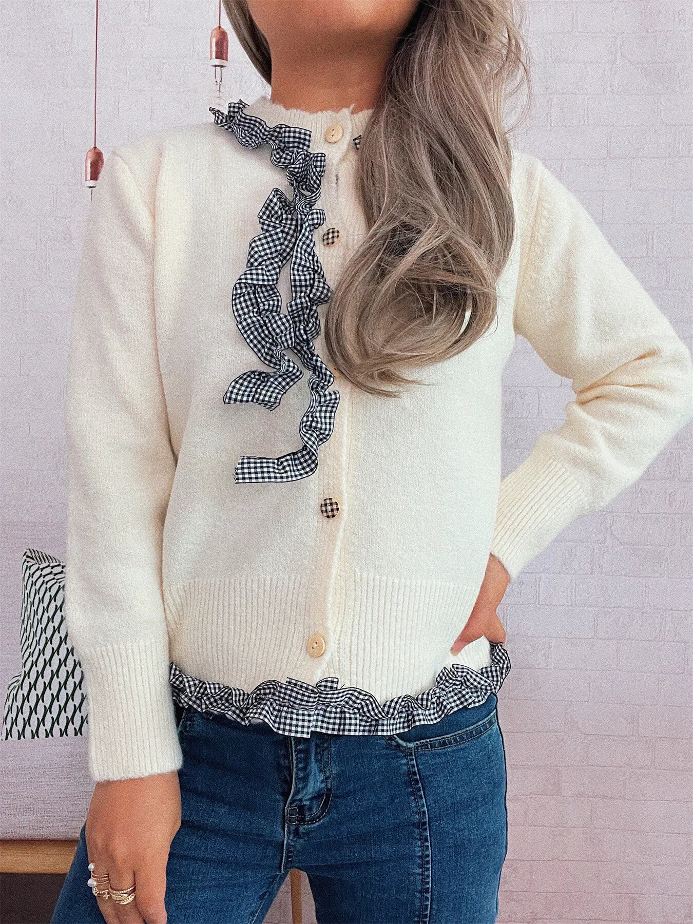 Lightweight gingham cardigan with ruffle trim and button closure, made of 100% polyester.