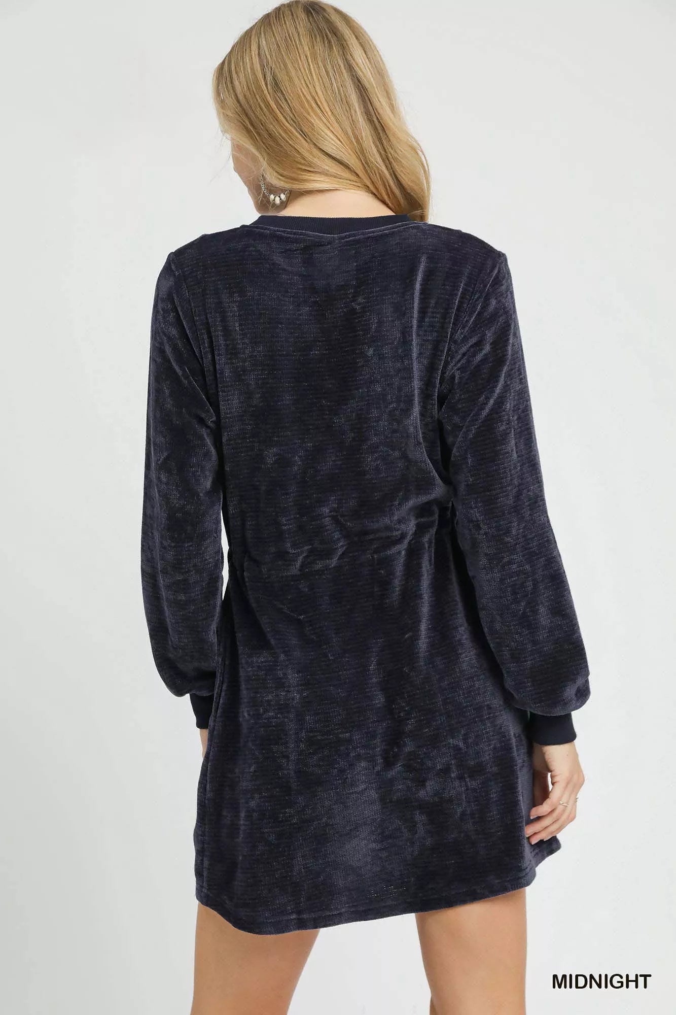 Rear view of navy velour drawstring long sleeve mini dress on model.