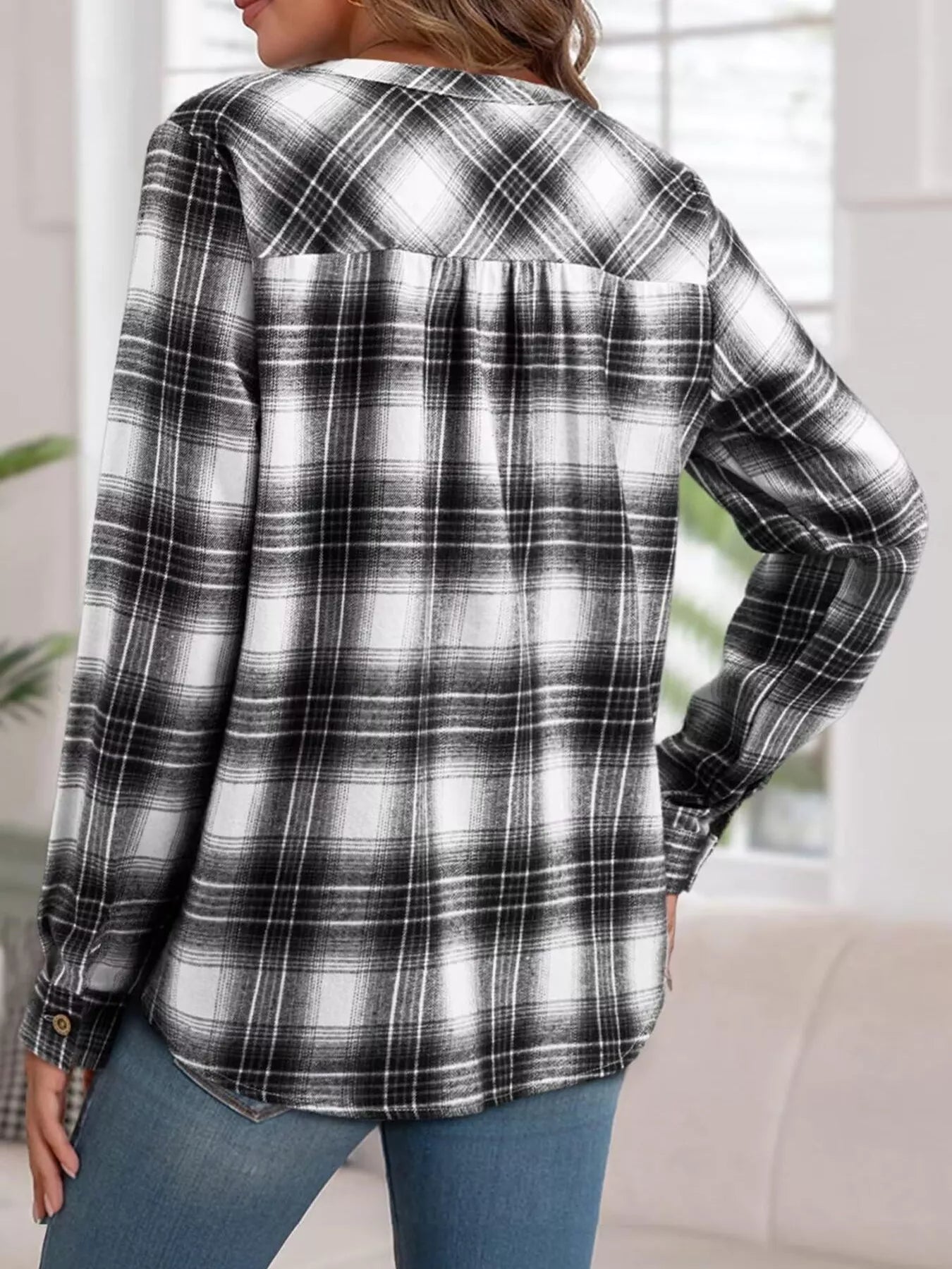 Plaid half-button long sleeve blouse made of polyester blend with a relaxed fit.