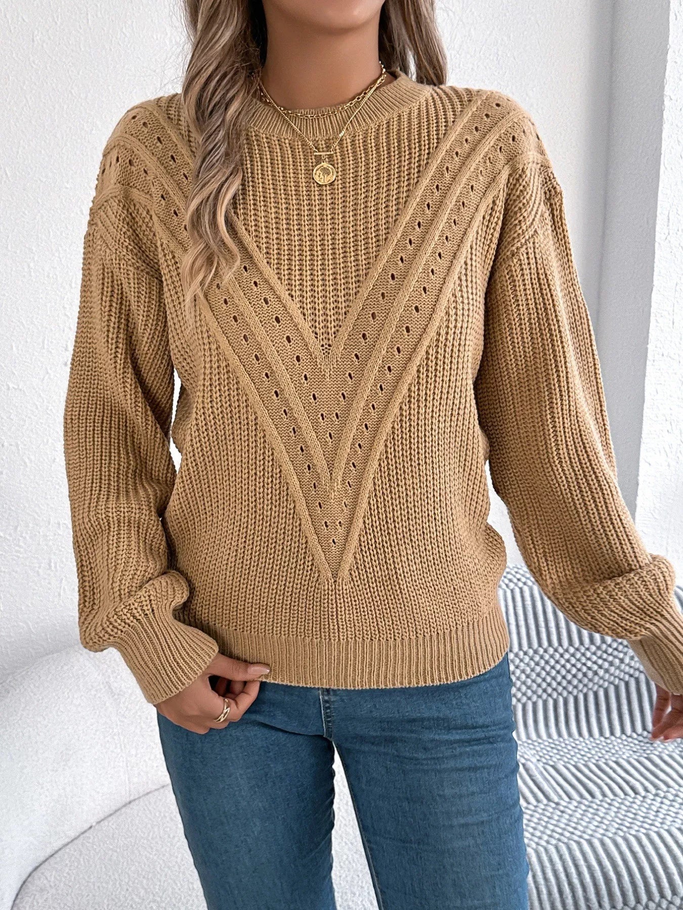 Openwork acrylic sweater with a round neck and slightly stretchy, breathable knit design.