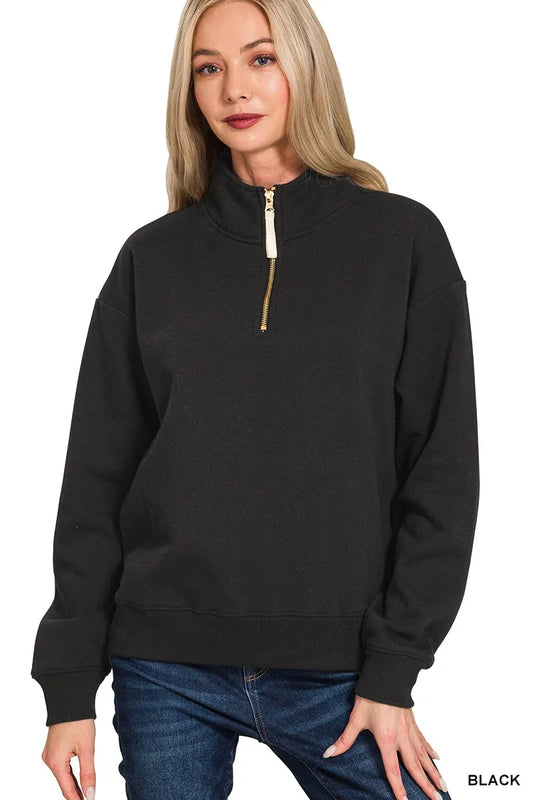 Black oversized fleece half-zip sweatshirt with gold zipper on a model.