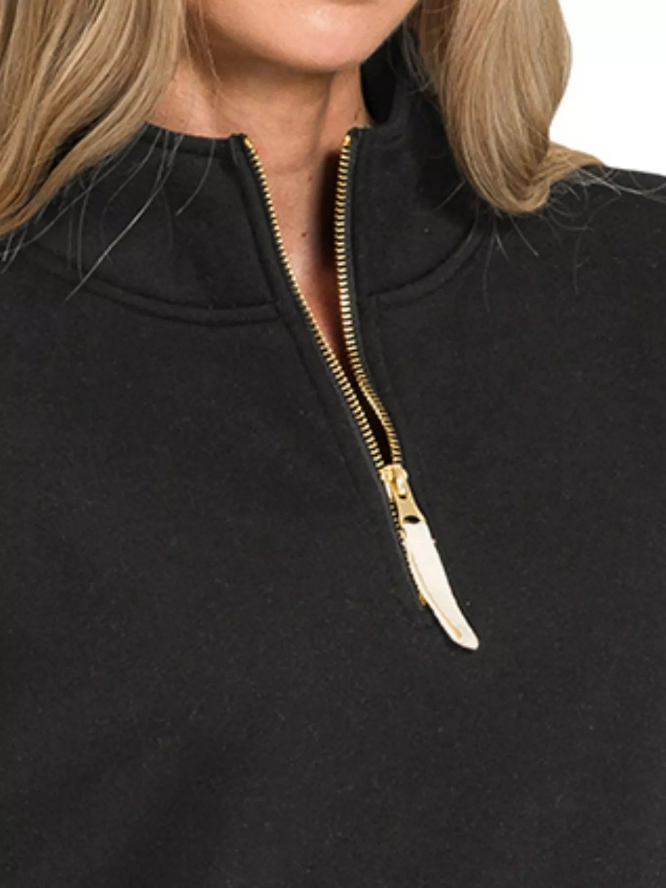 Black oversized fleece half-zip sweatshirt with gold zipper detail.
