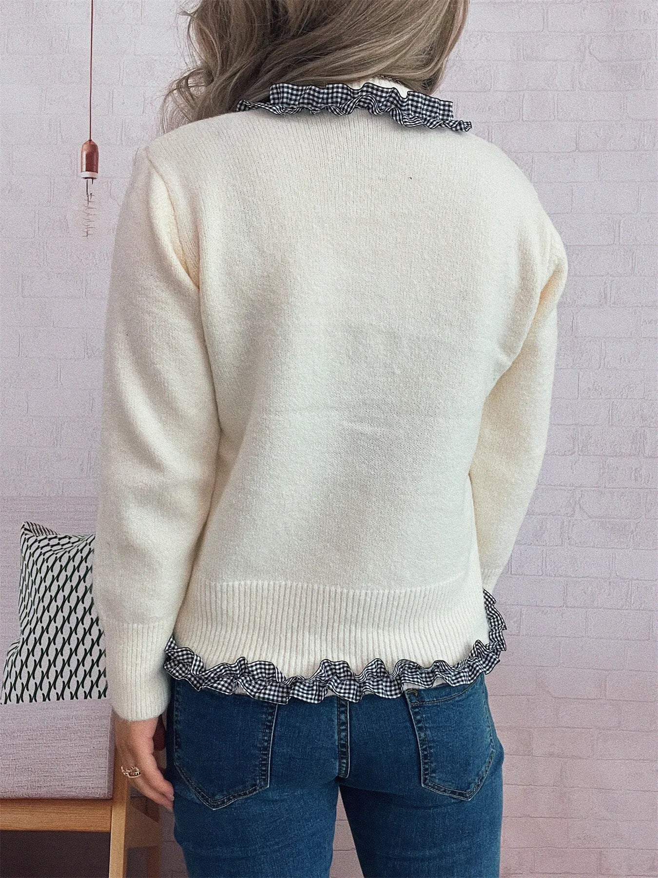 Lightweight gingham cardigan with ruffle trim and button closure, made of 100% polyester.
