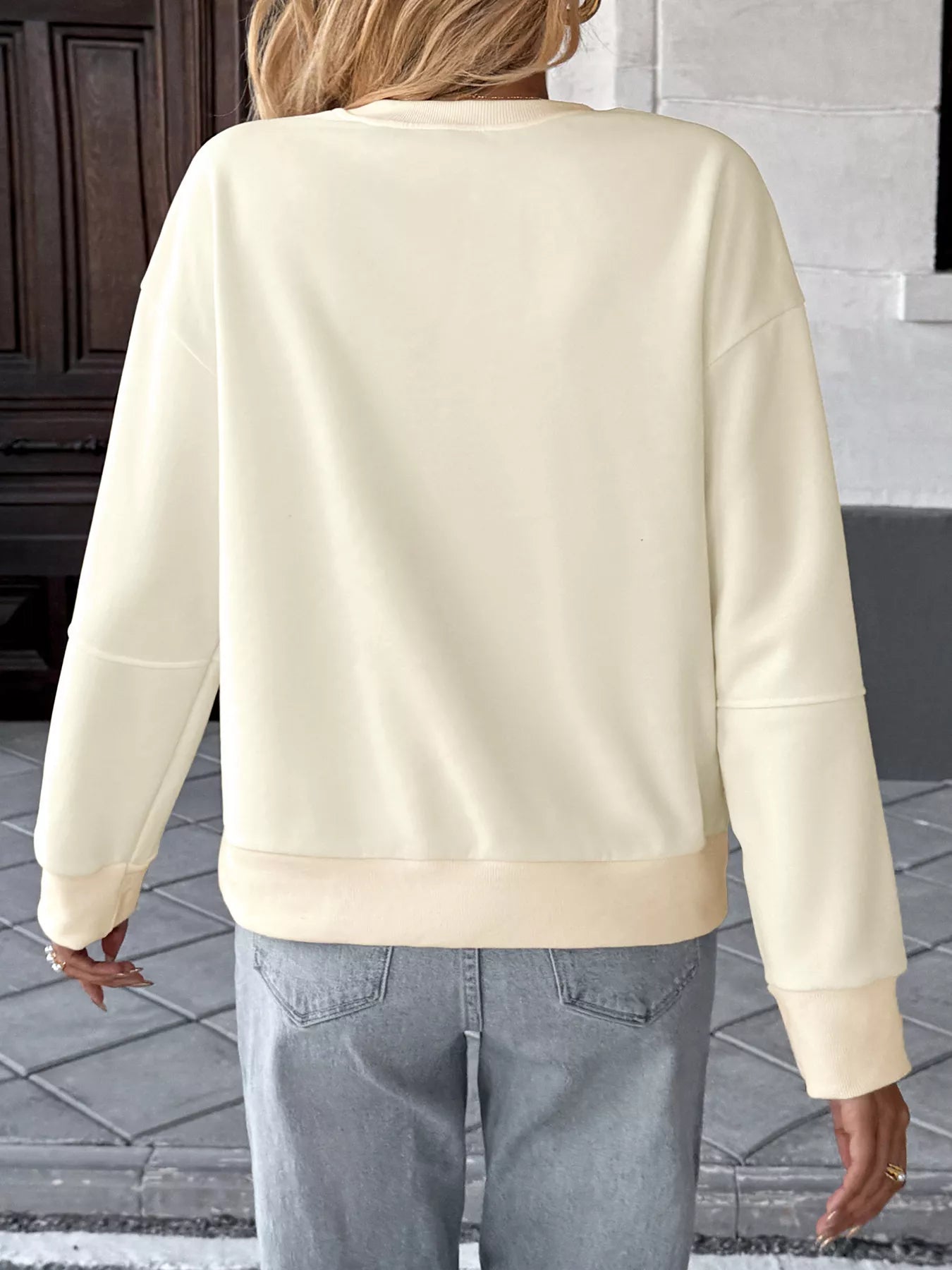 Gray sweatshirt with a bow detail, round neck, and dropped shoulders.