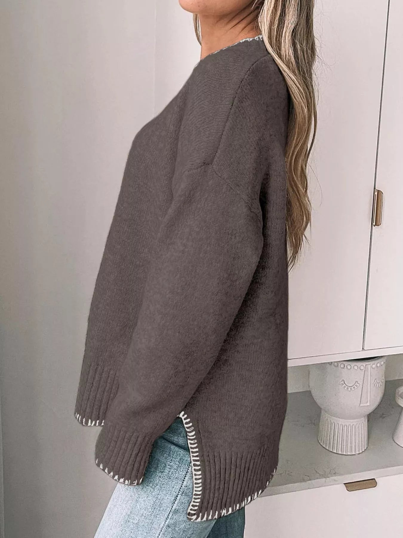 Round neck sweater with slit and contrast trim in a viscose blend fabric.
