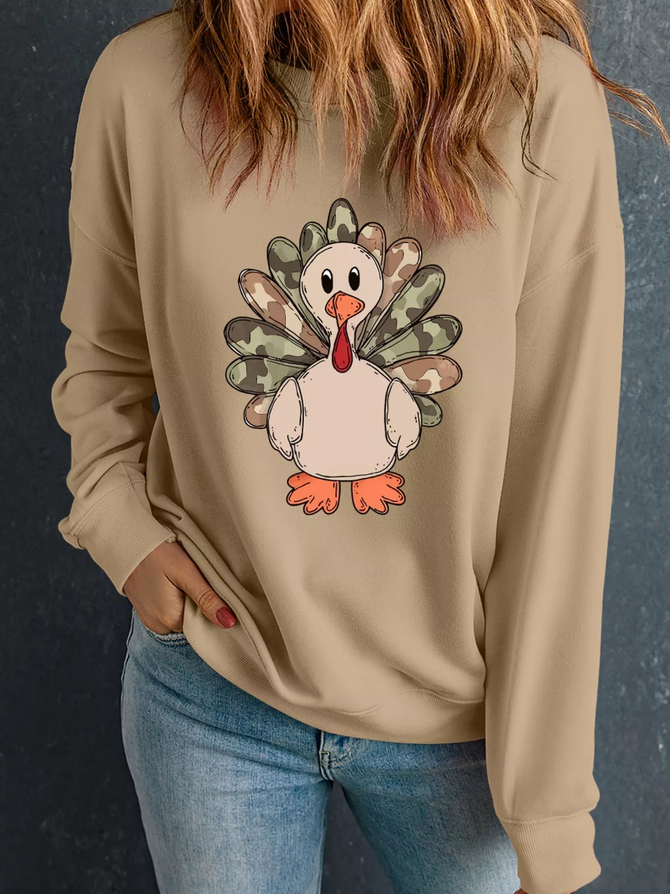Beige sweatshirt with camouflage turkey graphic and long sleeves.