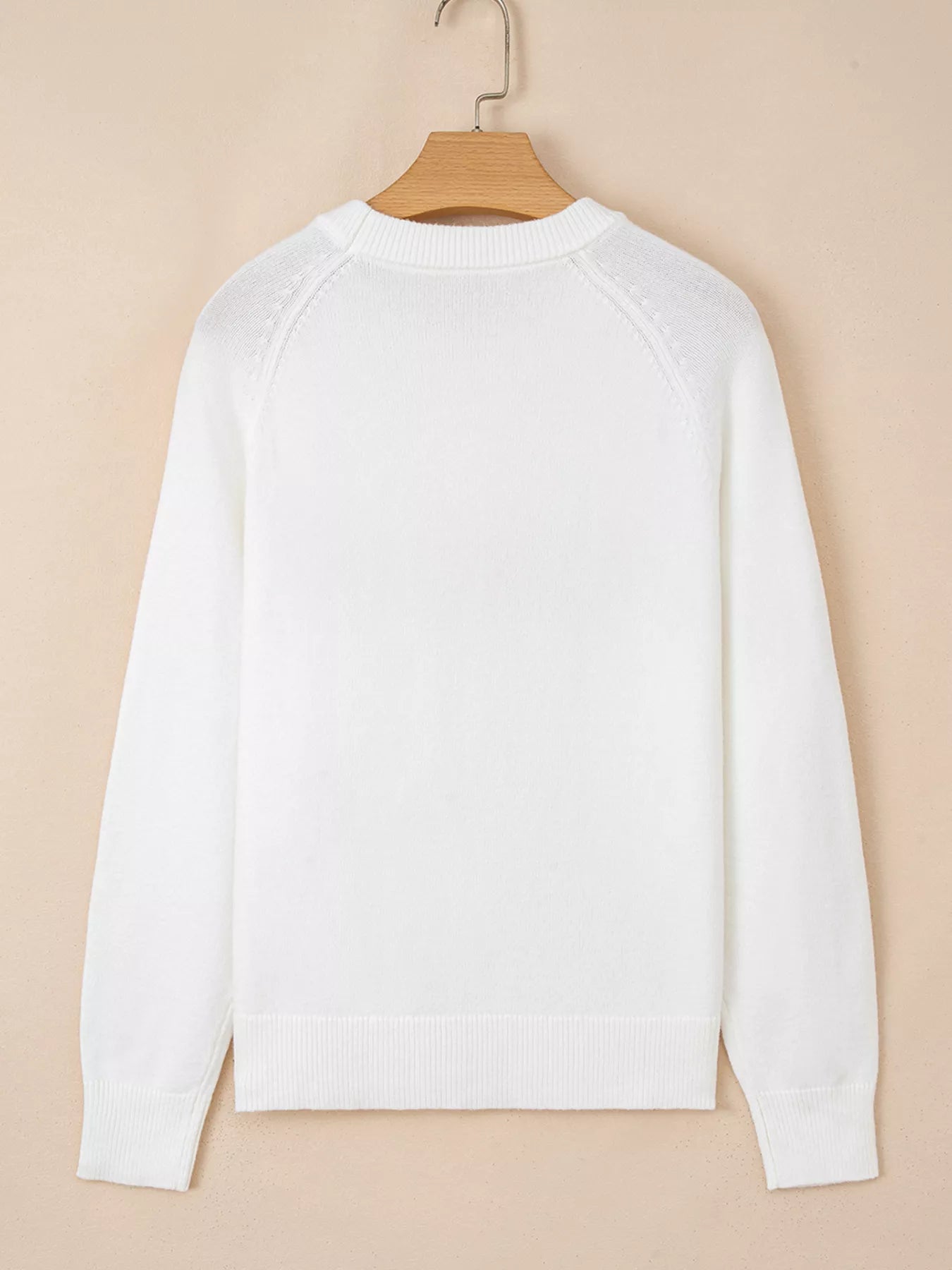 A soft viscose blend sweater with raglan sleeves and a subtle poodle motif.